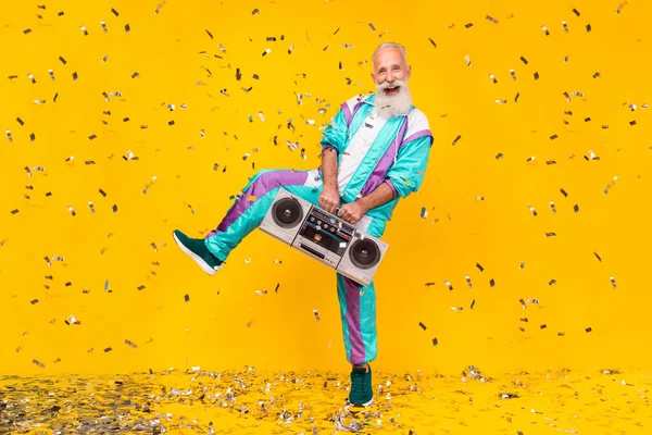 Full size portrait of overjoyed aged person hold carry boombox have fun wear 90s clothes set isolated on yellow color background.
