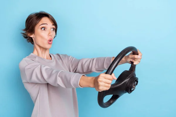Photo of gorgeous staring woman with bob hairdo dressed gray pullover hold steering wheel accident crash isolated on blue color background.