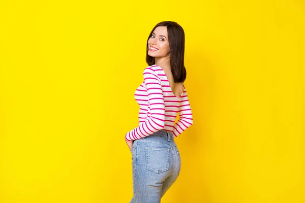 Side profile of dreamy sweet woman with bob hairdo dressed striped shirt standing back empty space isolated on yellow color background.