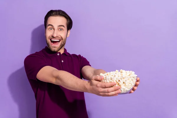 Photo of cheerful delighted funny man relaxing on weekend holiday watch cinema movie isolated on violet color background.