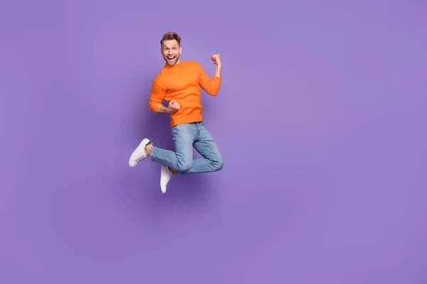 Full body photo of good mood laughing man raise fists in victory win money lottery isolated on violet color background.