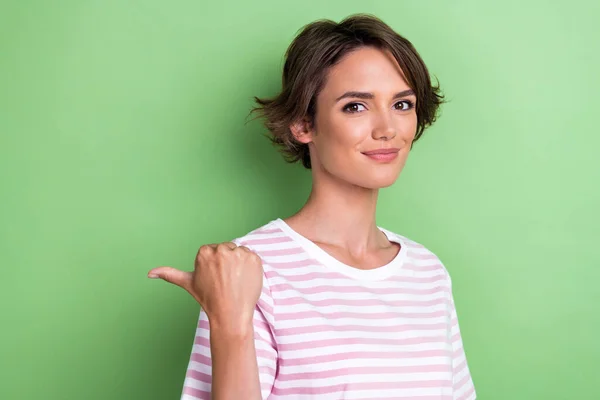Photo of cute bob hairdo young lady index up wear white striped t-shirt isolated on green color background.