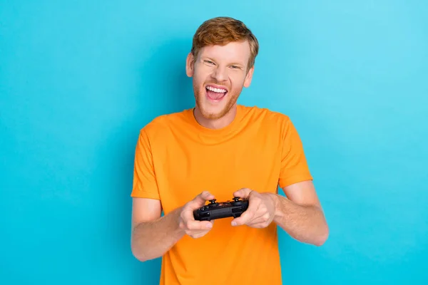 Photo of hooray ginger hair guy playstation wear orange t-shirt isolated on vivid blue color background.