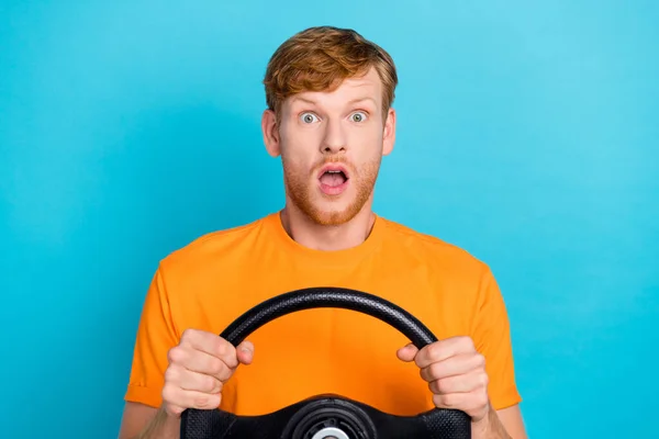 Photo of impressed ginger hair guy drive car wear orange t-shirt isolated on teal color background.