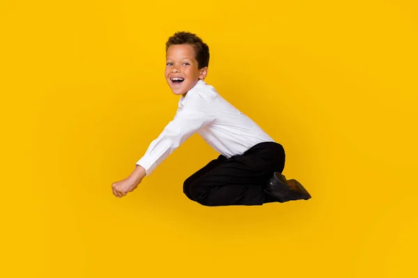 Full length profile portrait of crazy overjoyed person falling have fun isolated on yellow color background.