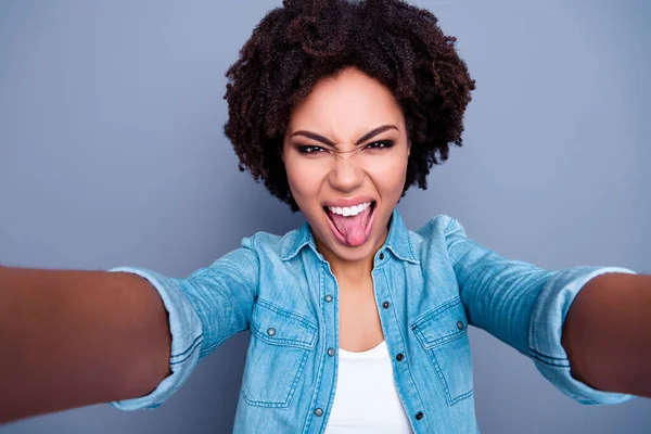 Photo of carefree excited girl take selfie showing tongue out protrude isolated on grey color background.