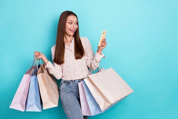 Foto Von Beeindruckt Junge Frau Halten Taschen Aussehen Telefon Tragen — Stockfoto