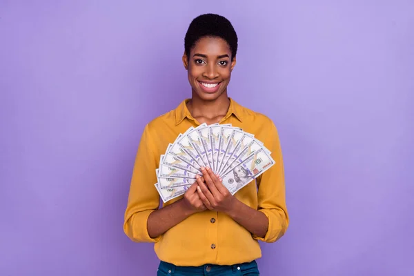 美しいトレンディーなブルネット陽気な女の子の肖像で手のファン現金銀行券私たちを隔離以上紫の色の背景 — ストック写真