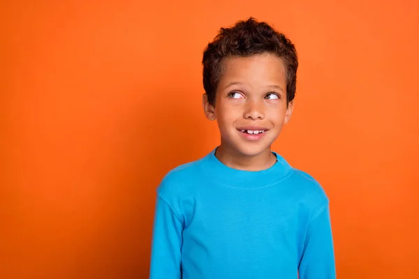 照片上漂亮可爱的男孩穿着蓝色时髦的毛衣 在空旷的空间看到用橙色背景隔开的广告横幅 — 图库照片