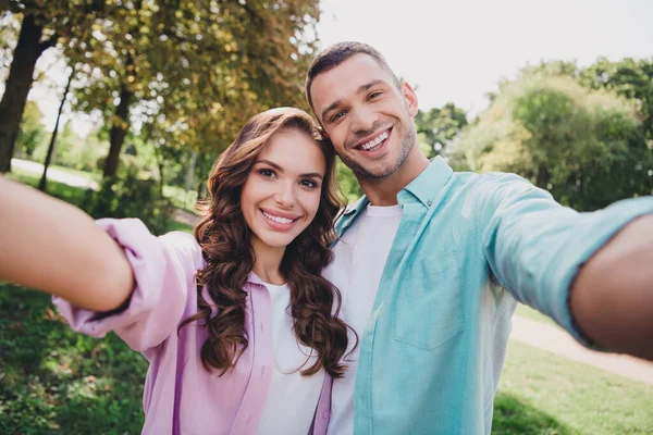 Portrait of two cheerful friendly people make selfie recording video toothy smile enjoy warm weather outdoors.