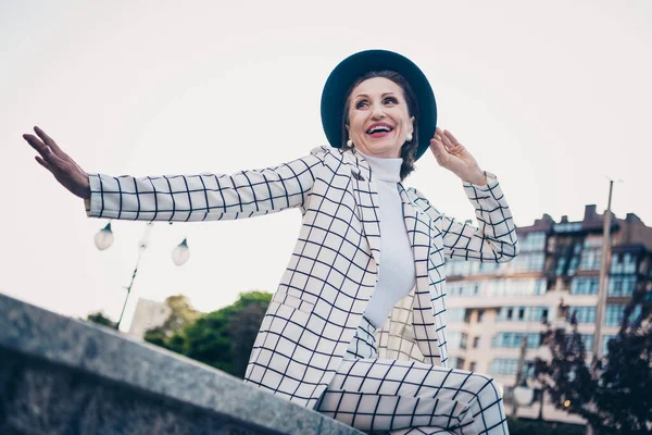 Photo of sweet excited lady dressed checkered blazer arm hand cap enjoying sunny weather outdoors urban town street.