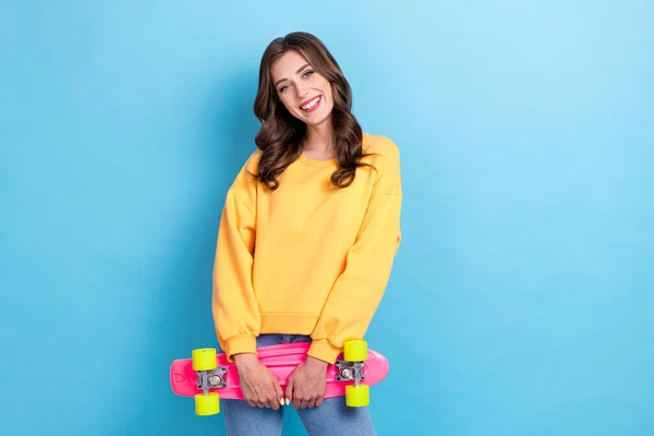可愛い若い女性の写真の肖像ピンクのスケートボードスポーツ用品プロモーションは 青の色の背景に隔離された流行の黄色の服を着用 — ストック写真