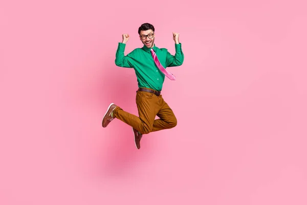 屈託のない幸運男の完全な長さ写真は緑のシャツ眼鏡を着用上昇拳ジャンプ高い孤立したピンク色の背景 — ストック写真