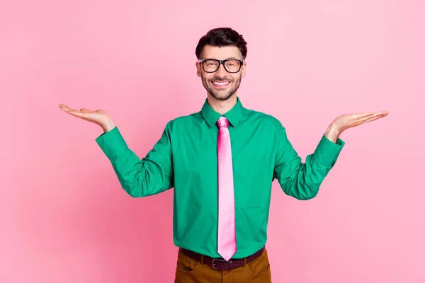 若い笑顔の男の肖像緑のシャツを保持手比較価格ショップピンクの色の背景に孤立 — ストック写真