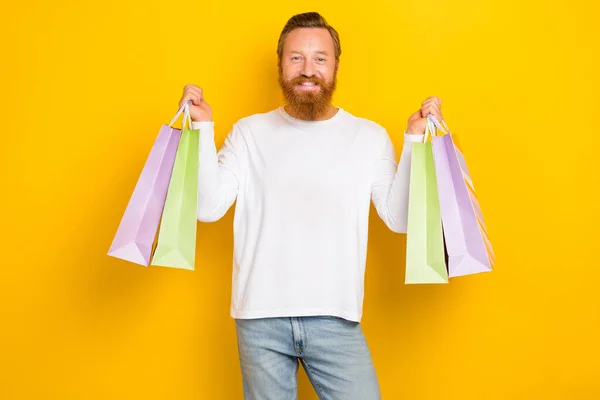 Photo satisfied positive man hand arm hold new clothes choose nice outfit enjoy isolated on yellow color background.