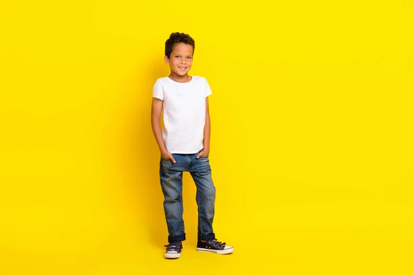 男の子の完全な長さの写真は 黄色の色の背景に隔離されたTシャツのジーンズブーツを着用スタンド — ストック写真