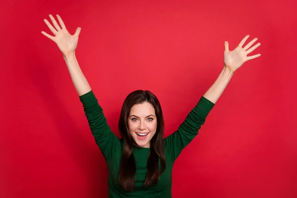 Photo of shiny content woman hairstyle raise arms get hired dressed trendy green long sleeve shirt isolated on vivid red color background.
