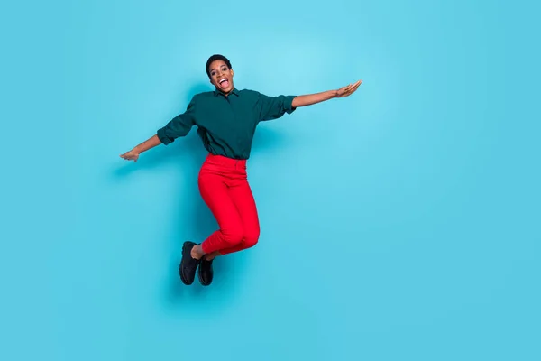 Photo of funky attractive androgynous human wear green shirt jumping high empty space isolated blue color background.