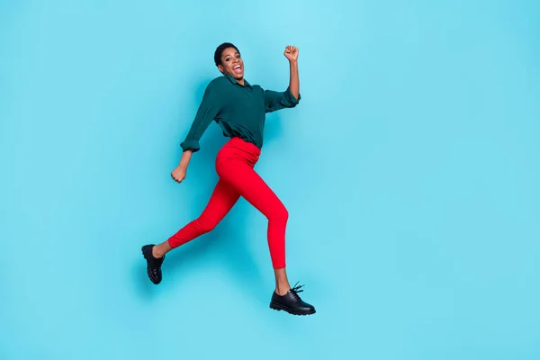 Photo of pretty sweet trans person dressed green shirt jumping high running fast empty space isolated blue color background.