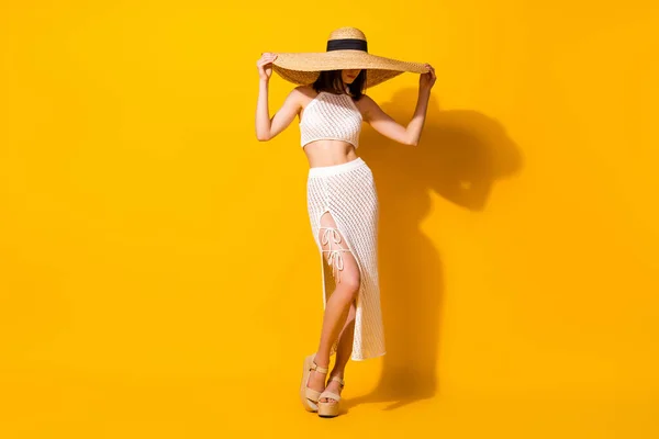 完全な長さ写真のかなり光沢のある女性の着用ホワイトセット保持腕手ヘッドウェア隔離された黄色の背景 — ストック写真