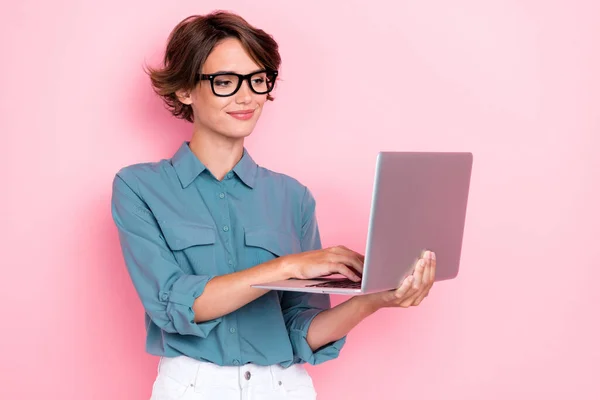 若い魅力的な可愛い素敵なかわいい女性の閉鎖写真は ノートパソコンを保持オンラインリモートコールタイピング着用眼鏡ピンク色の背景に隔離された — ストック写真