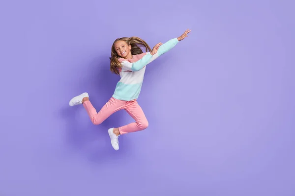 フル長いです写真のファンキー甘いです小さな女の子身に着けているスウェットシャツジャンプ高い空のスペース隔離された紫色の背景 — ストック写真