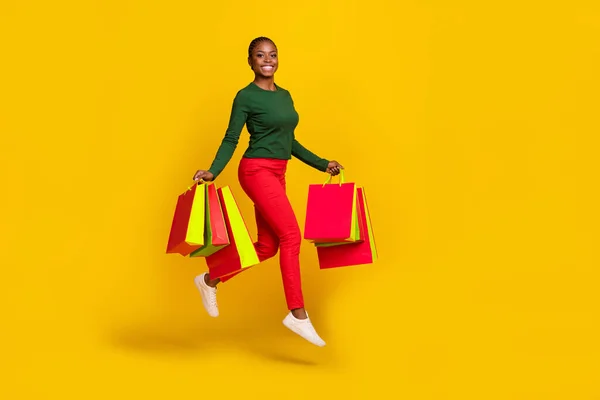 여자가 초록색 셔츠를 고립된 노란색 배경을 뛰어넘는 쇼핑객들을 — 스톡 사진