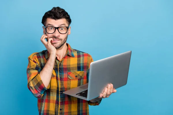 有压力的黑发男人拿着笔记本电脑 穿着蓝色背景的眼镜格子呢衬衫的照片 — 图库照片