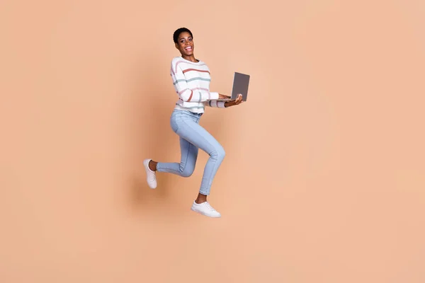 Photo of pretty excited trans human dressed pullover jumping high running chatting gadget isolated beige color background.