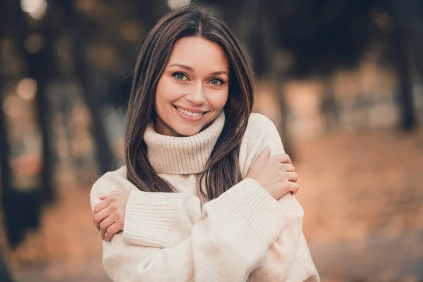 暖かい襟のセーターを身に着けている愛らしい甘い女性の写真は 都会の公園外の晴れた天気を楽しんで抱きしめる笑顔 — ストック写真