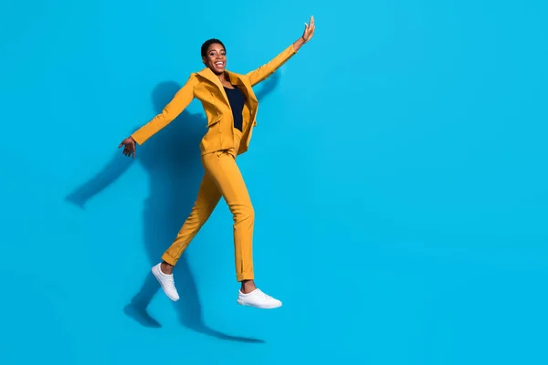 Full body profile side photo of young excited girl guy have fun jump energetic walk isolated over blue color background.