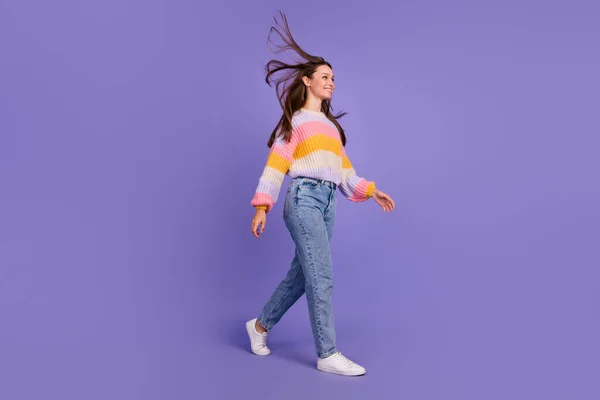Full body profile portrait of gorgeous carefree girl walking look empty space isolated on purple color background.