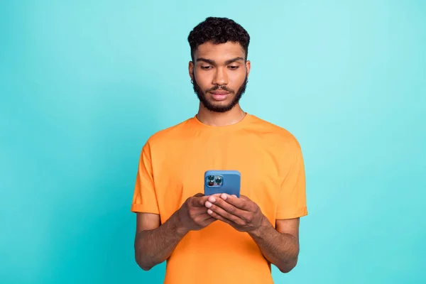 严肃自信的男人穿着橙色T恤聊天的照片安塔格拉姆Twitter Facebook现代设备隔离绿松石色背景 — 图库照片