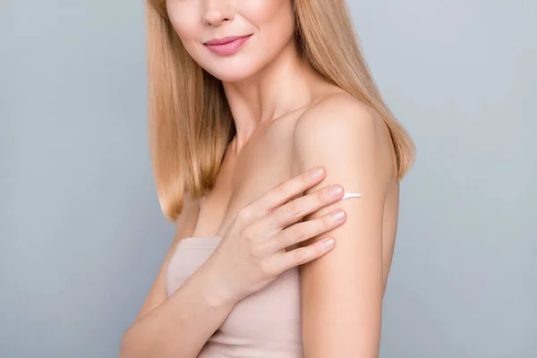 Cropped photo of mature lady apply hydration lotion silky soft aesthetic hand skin isolated over grey color background.