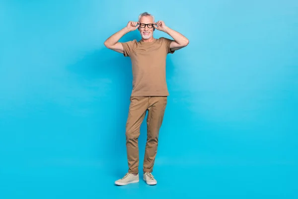 Full body portrait of cheerful man arms touch eyewear good mood isolated on blue color background.