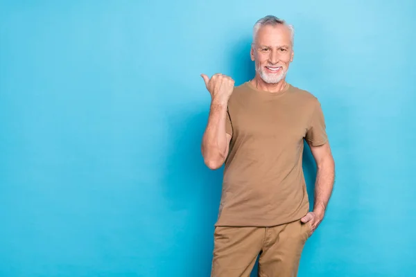 魅力的な引退した男性の写真は 青い色の背景に隔離された直接空のスペースクールな提案販売のパステル衣装アームを着用 — ストック写真