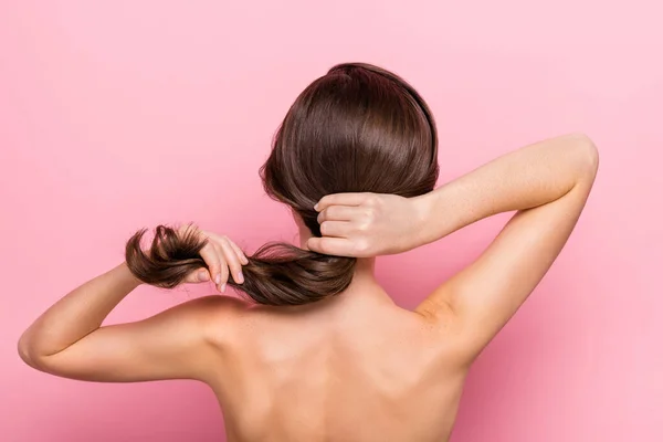 リアバック後ろビューの肖像画の魅力的な女の子のタッチ絹のような髪現代的な化粧ピンクパステルカラーの背景に孤立 — ストック写真
