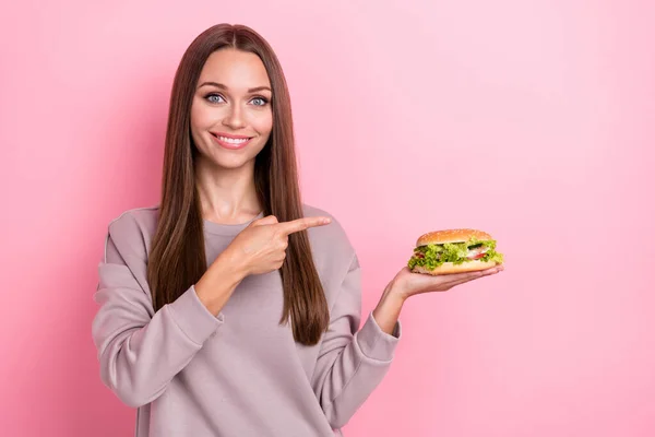 손으로 긍정적 소녀의 모습은 분홍색 배경에 햄버거 샌드위치를 — 스톡 사진