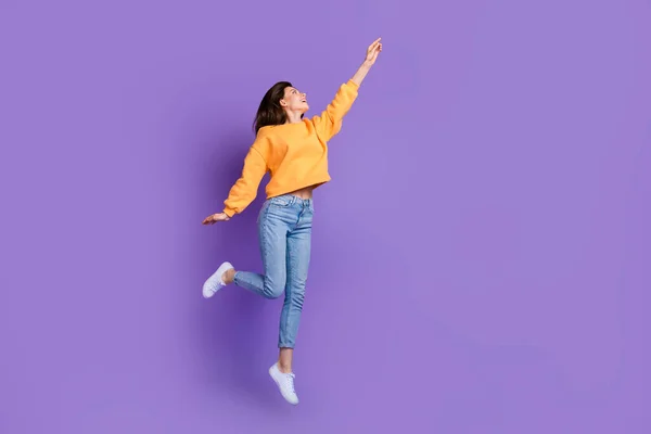 若いスポーツ女性のフルボディ長さの写真飛行トランポリン指ポイント空のスペース広告のんきな紫色の色の背景に隔離 — ストック写真
