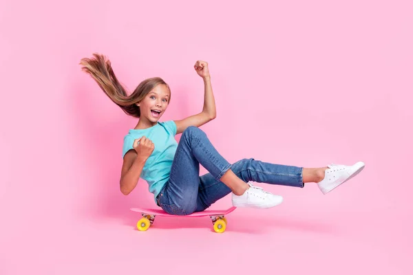 かわいい運の良い小さな子供の完全な長さの写真ドレスのTシャツ上昇スケートボード見て上昇拳孤立ピンク色の背景 — ストック写真