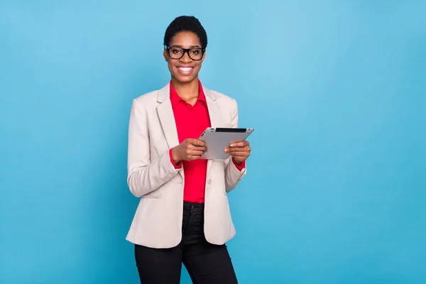 Portrait of attractive cheerful executive director broker using tablet blogging isolated over bright blue color background.