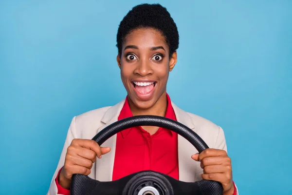 Portrait of astonished excited person hold wheel open mouth isolated on blue color background.