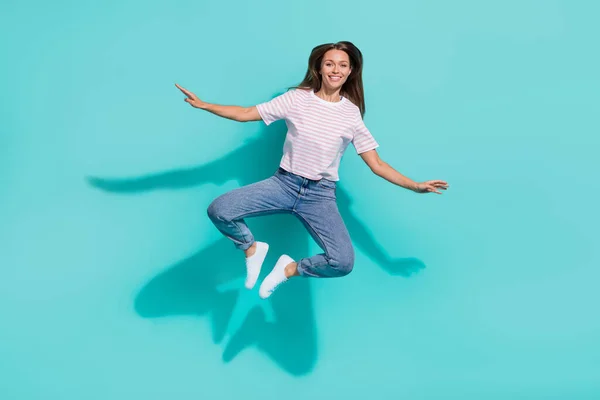 フルサイズ写真の女の子明るい女性で長い髪型の縞模様のTシャツのジーンズ飛行孤立したティール色の背景 — ストック写真