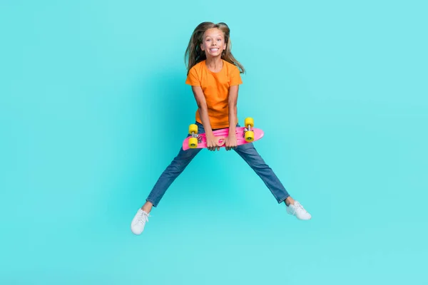 甘いかわいい小さな子供の完全な長さの写真は オレンジのTシャツを着て上昇ロングボードジャンプ高隔離されたターコイズ色の背景 — ストック写真