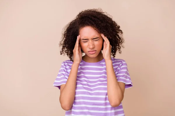 Photo of stressed upset lady wear violet t-shirt arms temples closed eyes isolated beige color background.