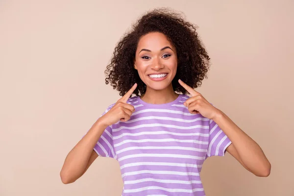 ファンキーな女性の写真は 紫色のTシャツを着用指差す指白い歯孤立ベージュ色の背景 — ストック写真