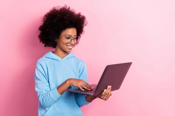 可爱的女生拿着手提电脑眼镜做作业的照片肖像 穿着时髦的蓝色衣服 背景是粉色的 — 图库照片