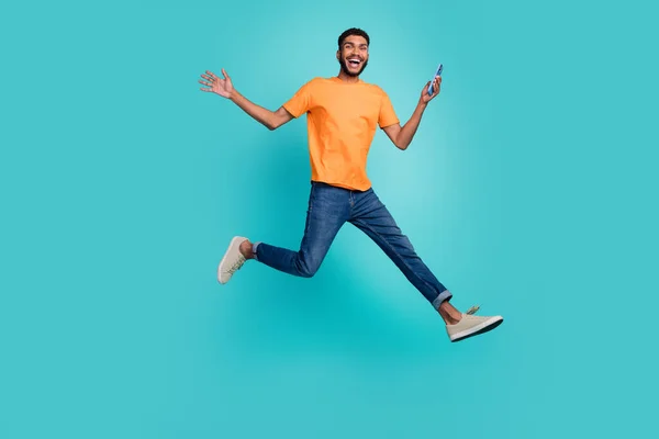 Full Length Photo Excited Positive Guy Wear Orange Shirt Jumping — Zdjęcie stockowe