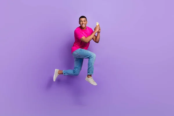 フルサイズプロフィールポートレートのアクティブハンサムな男ジャンプラッシュホールド使用電話絶縁上の紫の色の背景 — ストック写真