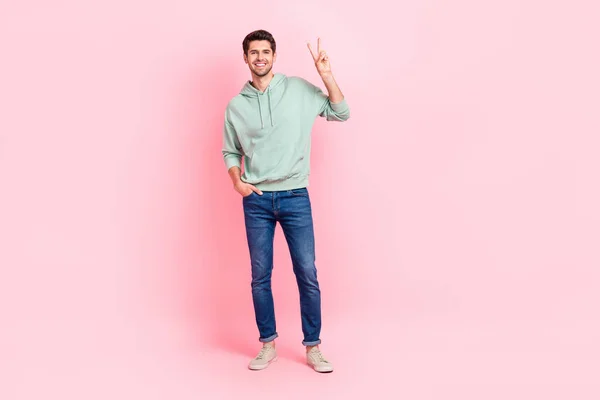 満足のいく若い男の完全な長さの写真置く腕ポケットデモンストレーションV Sign孤立したピンク色の背景 — ストック写真